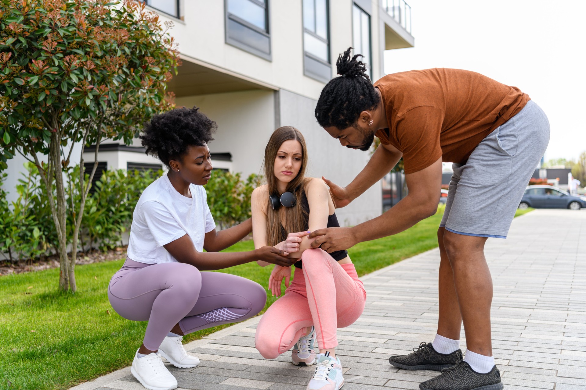 A Couple of Africans is Helping a Woman with a Leg Injury.